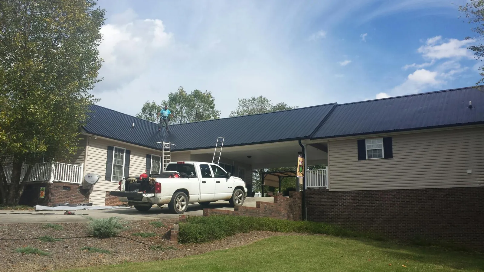 Black metal roof over a home and attached breezeway with ladders set in Centralia